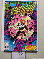Front cover of Daredevil #169 featuring Bullseye in a black costume surrounded by pink-clad characters, with vibrant and detailed comic art.