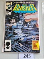 Front cover of The Punisher #1 comic book showing detailed character wielding guns in an action pose among gunfire and bullets. Comic is encased in protective bag with price and issue info visible.