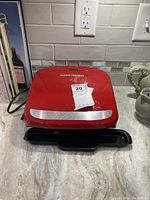 Red George Foreman Grill model GRP 360R shown from top view with removable drip tray below.