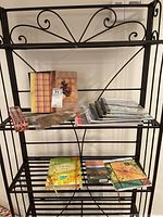 Shelf containing journals and sketch pads with various decorative covers, some with floral and natural motifs.