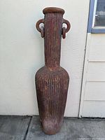 Full front view of tall ribbed terra cotta vase