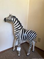 Full left-side view of zebra sculpture standing in corner