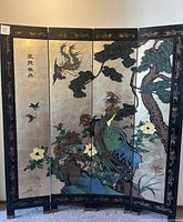 Front view of the four-panel folding room divider showing painted birds, flowers and trees on metallic background with black lacquer frame and gold-tone decorative accents.
