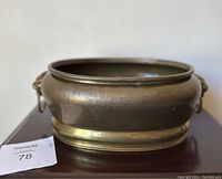 Front view of the vintage brass pot, showing the round shape and aged brass surface.