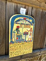 Photo showing front of vintage wooden stele with detailed painting and hieroglyphs