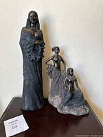 Front view of both African statues showing detailed figures and texture