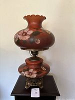 Full view of vintage Gone With the Wind parlor lamp, showing floral glass globe on ornate metal base.