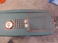 Copper wire basket, copper wall hanging and copper trivet arranged on a green surface for clear view