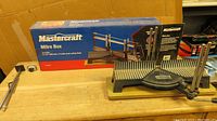 Mastercraft mitre box with packaging box in background, sitting on a wooden table.