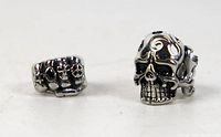 Close-up photo of the two rings focusing on details of the skull designs.