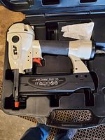 Side view of ET&F finish nailer inside its case showing the tool and some included items.