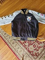Front view of black and gray Steelers varsity jacket with Super Bowl Champions embroidery and logo.