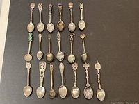 Overview of 19 spoons arranged in three rows on black background