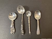 Four spoons arranged on black background