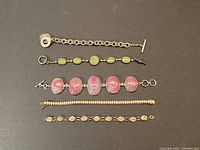 All five bracelets laid out on black background