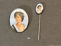 Front view of brooch and stick pin showing hand painted female portraits