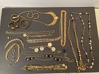 Overview of all jewelry pieces laid out showing variety of chains, bracelets, earrings, and rings.
