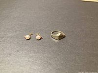 Ring and earrings arranged on dark background showing overall lot