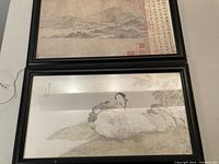 Two framed prints shown, vertically stacked. Top print is a landscape with mountains and script. Bottom print shows a woman sitting on rocks in nature.