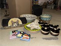Photo showing five French onion crocks, ceramic bowls, Thanksgiving platter, three tile trivets, and other decorative items