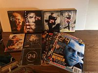 Four DVD cases of seasons 5 to 8 of TV show 24, twelve official magazine copies and original soundtrack CD.