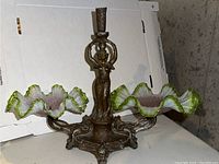 Full view of vintage brass and glass candle holder with two ruffled glass dishes and central female figurine holding a candle sconce.
