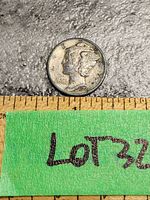Top-down close photo of a 1943 US Mercury Dime coin showing obverse side with Winged Liberty head, dated 1943. Coin placed above measuring tape for scale.