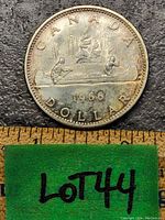 Obverse side of the 1966 Canadian silver dollar coin showing the Voyageur design with canoe and paddlers, some tarnish visible.