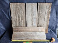 Five barn boards displayed on dark fabric background, showing texture and natural wear.