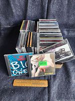 Multiple stacks of signed music CDs by various artists, including visible titles and album artwork.