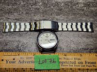 Seiko automatic wristwatch with metal bracelet band and ruler for size reference showing approximately 7 inches band length.