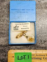Blue original box with label 'Murdoch's Gem Shop Ltd. Whitehorse, Y.T.' holding a gold-toned brooch with attached clear capsule pendant filled with small gold nuggets. Includes a card reading 'Genuine Klondike Gold Nuggets'.