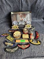 Overview of all items including large metal container, advertising tins, and patches.