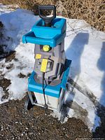 Front view showing overall unit, collection bin attached, wheels and feed hopper