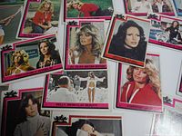 Close-up photo of multiple Charlie's Angels cards showing various lead characters and scenes from the 1977 TV series