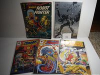 Five vintage Magnus Robot Fighter comics shown from front, displaying covers with colorful and black and white artwork featuring robots and fight scenes.