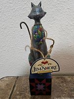 Front view of the Leona Grey Cat figurine showing detailed floral painting on the body, face and tag with Jim Shore branding.
