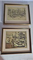 Two framed Lionel Barrymore gold foil etching prints laid flat, showing harbor scenes with boats and dock buildings