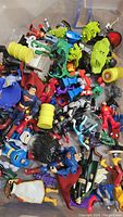 Overview of assorted action figures including Superman, Batman, Joker, Wolverine, and Transformers in loose piles