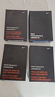 Four black Nike Performance Swimwear boxes, each containing a pair of swim briefs.