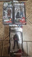 Lot of three Walking Dead action figures in original packaging, including Carol, Michonne, and Michonne's Pet 1