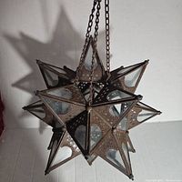 Full view of vintage Moravian star hanging tealight holder showing star shape, metal frame, glass panels, and hanging chain.