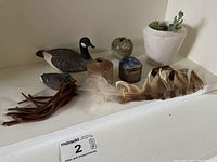 Ducks, boxes, feather and small decorative pottery on shelf