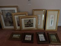 View of all nine framed prints arranged on carpet, showing variety of sizes and frame styles.
