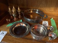 Group photo of two sets of salt and pepper shakers and several silver plate trays, showing items as a lot.