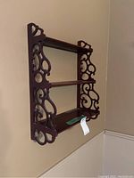 Side angled view showing the carved wooden decorative ends and horizontal slats forming the shelf.