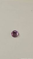 Top view of round purple-pink amethyst with diamond cut facets