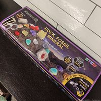 Closed box showing the kit branded 'Beicard' labeled 'Rock Fossil Mineral Activity & Dig Kit' with colorful gemstones illustrated on the front.