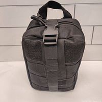 Closed tactical black carrying pouch for survival kit items