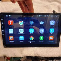 Front view of 9-inch Android car radio showing main app menu with icons like Music, Google, HERE WeGo GPS, DAB+, Settings, Bluetooth, Calculator, and Calendar.